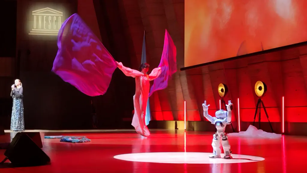 Duo scénique : le corps textile et le robot, sous le sigle de l'UNESCO.
